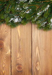 Christmas fir tree with snow on rustic wooden boardc