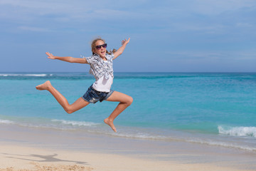 Fototapeta na wymiar Happy teen girl jumping on the beach