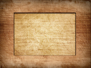 Brown scratched frame on light wooden board