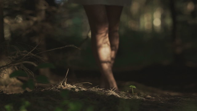 girl walking barefoot through the woods