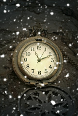 Christmas time. Vintage pocket watch and falling snow