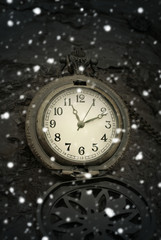 Fototapeta na wymiar Christmas time. Vintage pocket watch and falling snow