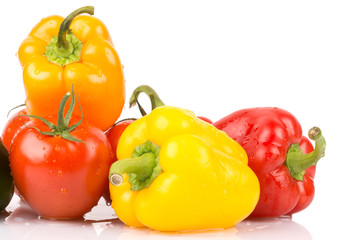 Close up of water drops on sweet vegatables: orange, yellow, red paprika and tomatoes on white isolated background.