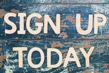 Sign up today written on rustic wooden surface
