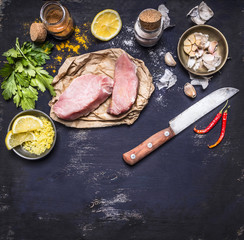 border Ingredients for cooking concept Turkey meat on a paper for a steak knife grated lemon herbs garlic pepper salt  on rustik wooden background  top view space for text banner for the web site