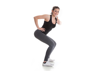 Frau macht Kniebeugen und zeigt Daumen hoch Porträt