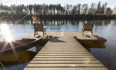 Two Chairs on Pier in River
