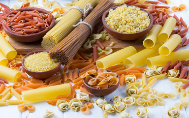 Variety of types and shapes of dry italian pasta. background