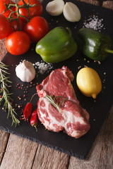 raw pork neck and vegetables close-up on board. Vertical
