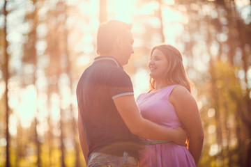 Romantic young couple kissing on background summer forest