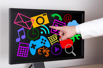 male hand pointing at big screen with applications and icons