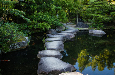 Step stones path over a pond in Koko-en Garden near White Egret Castle, in Himeji, Hyogo...