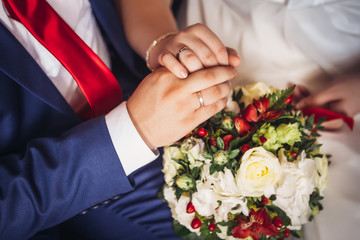 Obraz na płótnie Canvas hands of bride and groom on the bouquet