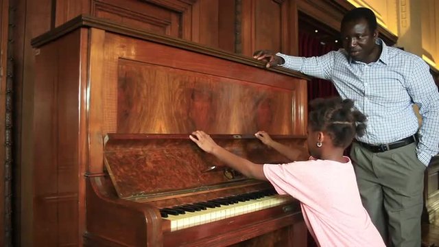 Father listening to his daugther playing piano