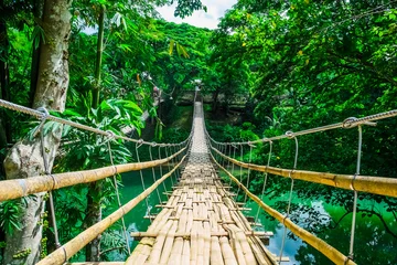 Rolgordijnen Bamboe voetgangers hangbrug over rivier © 12ee12