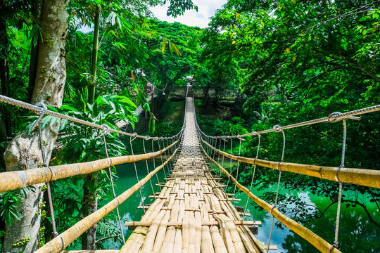 Fototapeta Bamboo pedestrian suspension bridge over river