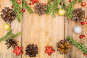 Christmas decoration on rustic wooden desk (pine cones, cinnamon, anise, spruce branches, red stars).