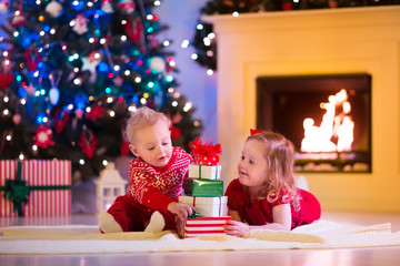 Fototapeta na wymiar Kids playing at fireplace on Christmas eve