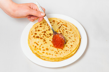 some pancakes on the white plate with red caviar