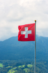 Swiss flag against Alps mountains