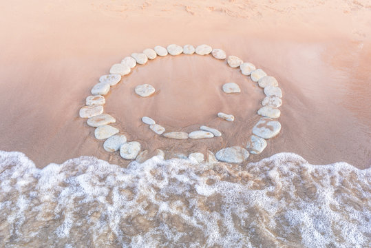 Emoticon of pebbles on sand