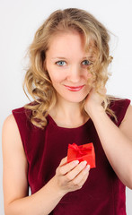 Cute young woman standing with gift box in her hand