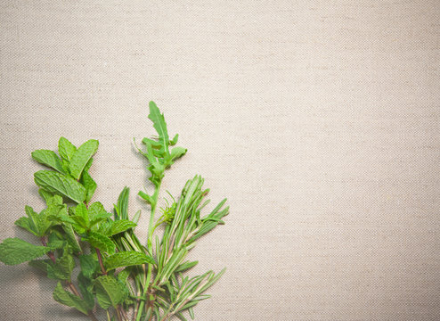 Fresh aromatic herbs on old linen background
