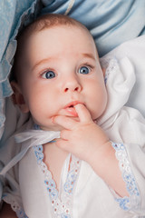 Funny baby boy with finger in mouth