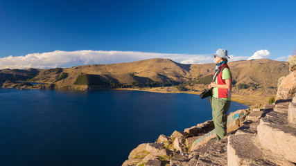 Fototapeta na wymiar Tourist looking at view from above, Titicaca Lake, Bolivia