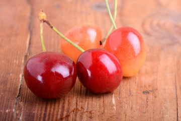 wooden plate with dark red juicy cherries close up