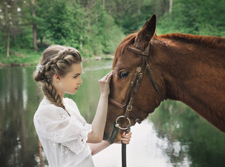 Woman in vintage dress touching to horse face