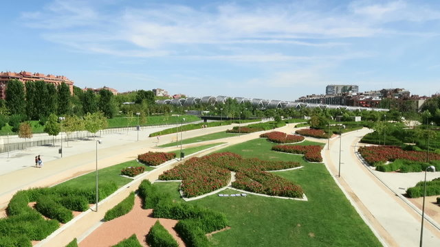 landmark cityscape of garden park with star shape flowers green lawn grass and modern metal bridge in Madrid city Spain Europe
