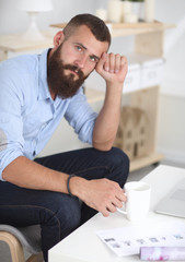 Fototapeta premium Young businessman sitting on chair in office