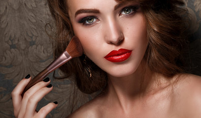 Beautiful woman with makeup brush