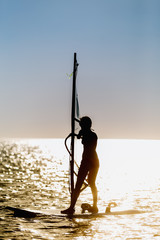 windsurfer silhouette against sun