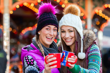 Frauen trinken Glühwein Becher auf deutschen Weihnachtsmarkt