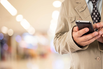 Man in shopping mall using mobile phone.