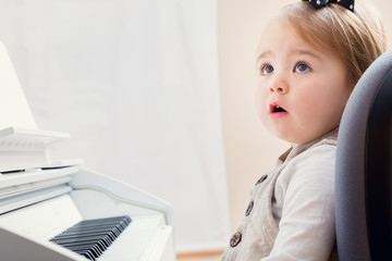 Toddler girl in front of a piano