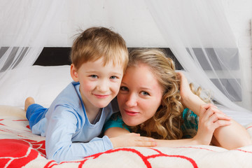 Happy woman with her child laying on belly