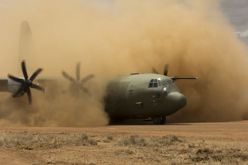 Air force plane lands on desert field airstrip to deploy troops