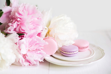 Macaroons on a plate in the flowers on a white background