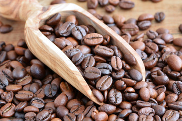 Kaffee - Kaffeebohnen geröstet auf Holzschaufel aus Olivenholz / Nahaufnahme - Makro