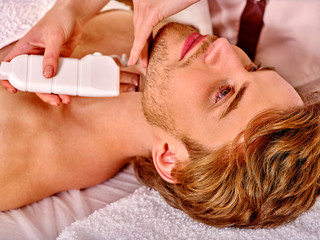 Obraz na płótnie Canvas Man receiving electric facial peeling massage.