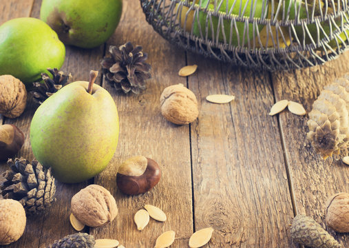 Autumn composition of fruits, nuts and spices - pears, walnuts  on a wooden background