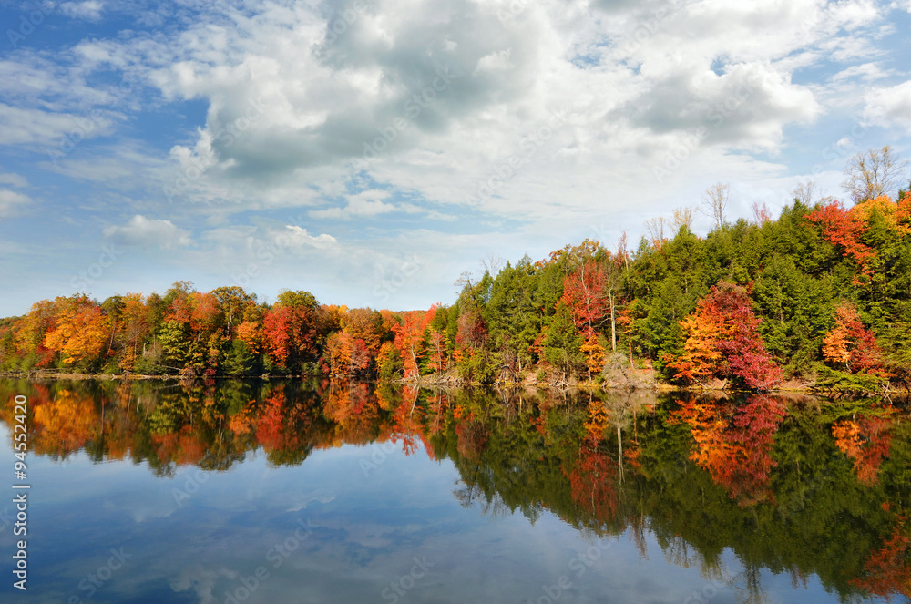 Wall mural beautiful autumn lake reflecting red fall colors in its clear water