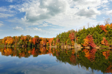Beautiful autumn lake reflecting red fall colors in its clear water - 94552420