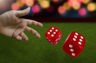 Male hand throwing dice on green felt