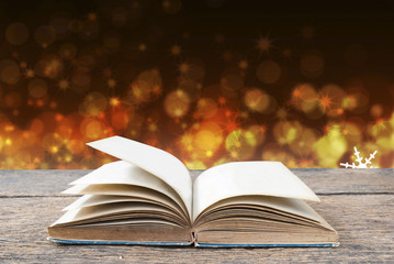 Abstract gold magic book on wooden background