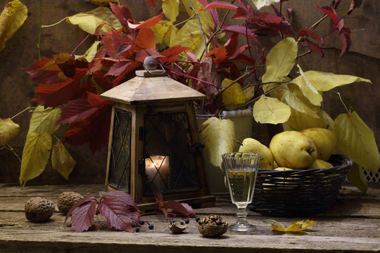 White wine and pears in a wattled basket and an old lantern