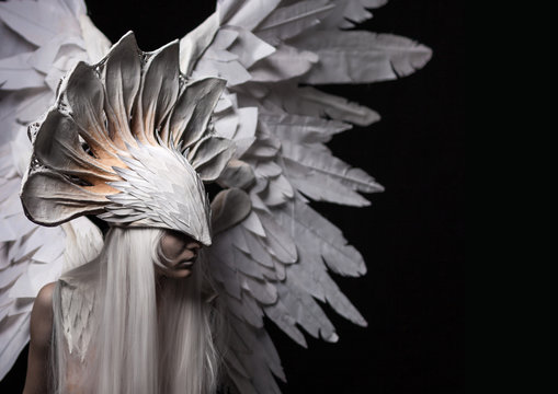 Angel, costume, concept, cinematic, a portrait of a young girl and a white wig , which carries a large white mask and a large white wings. Dramatic